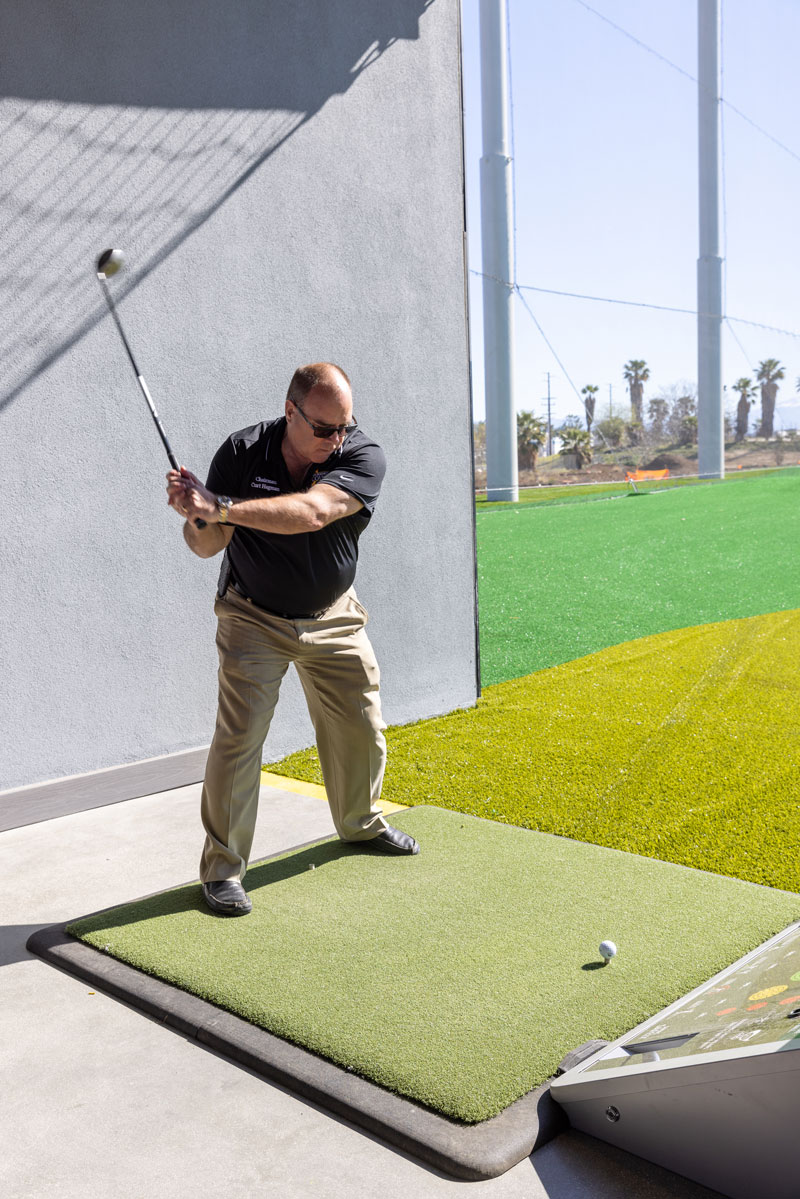 Supervisor Hagman swinging a golf club.