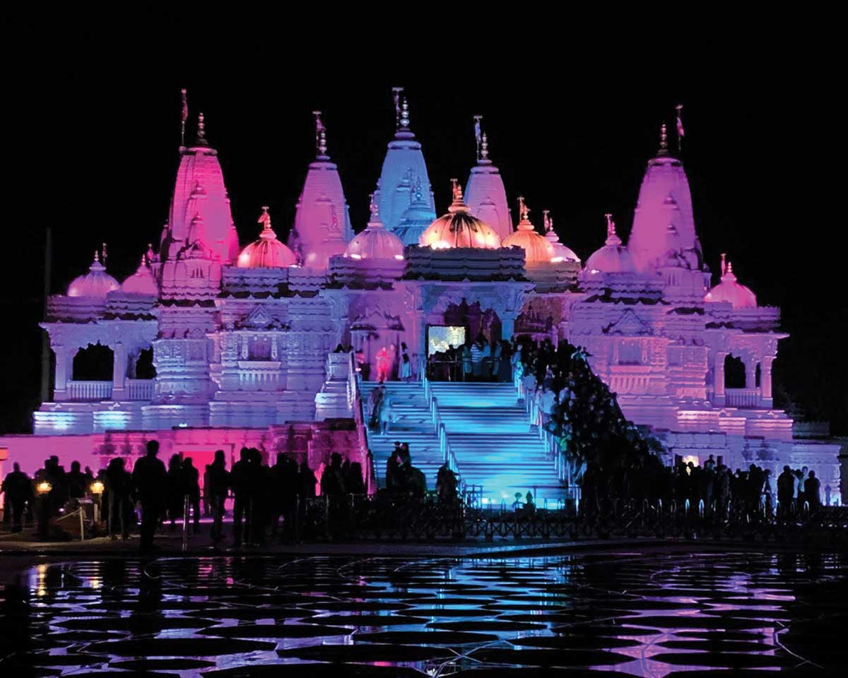 BAPS at night lit up in pinks and purples