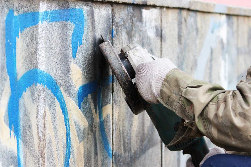 Grafitti being removed from concrete wall
