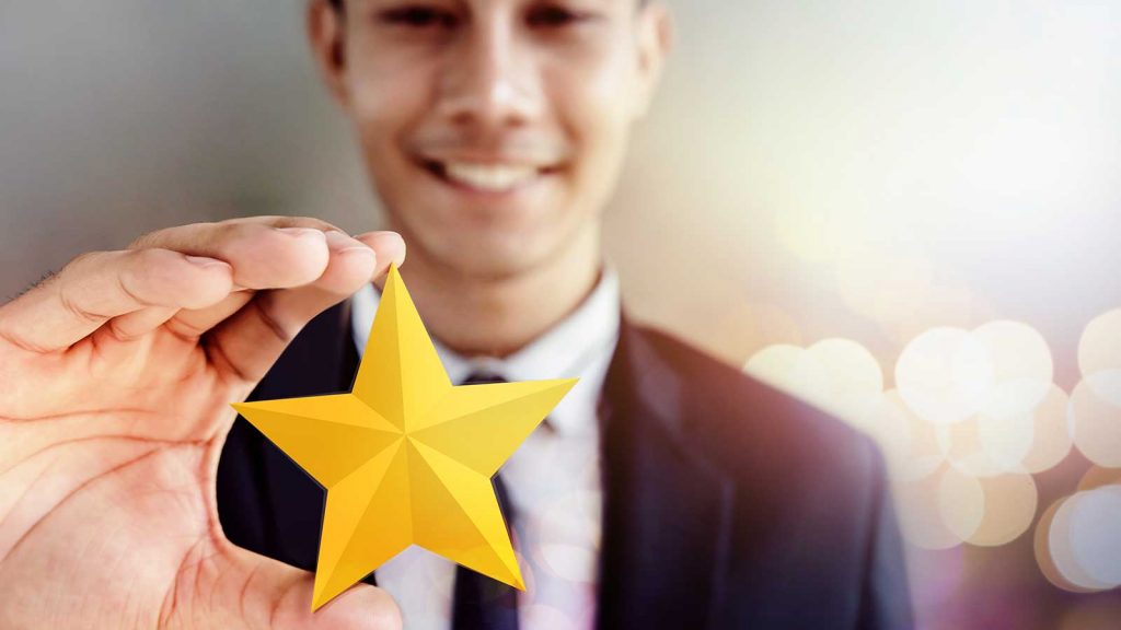 Smiling man holding a gold star