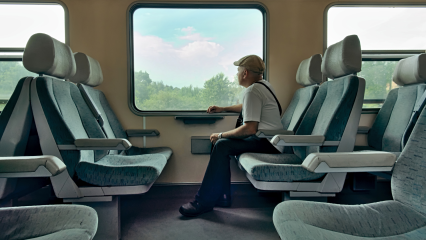 Man sitting in a train, looking out the window.