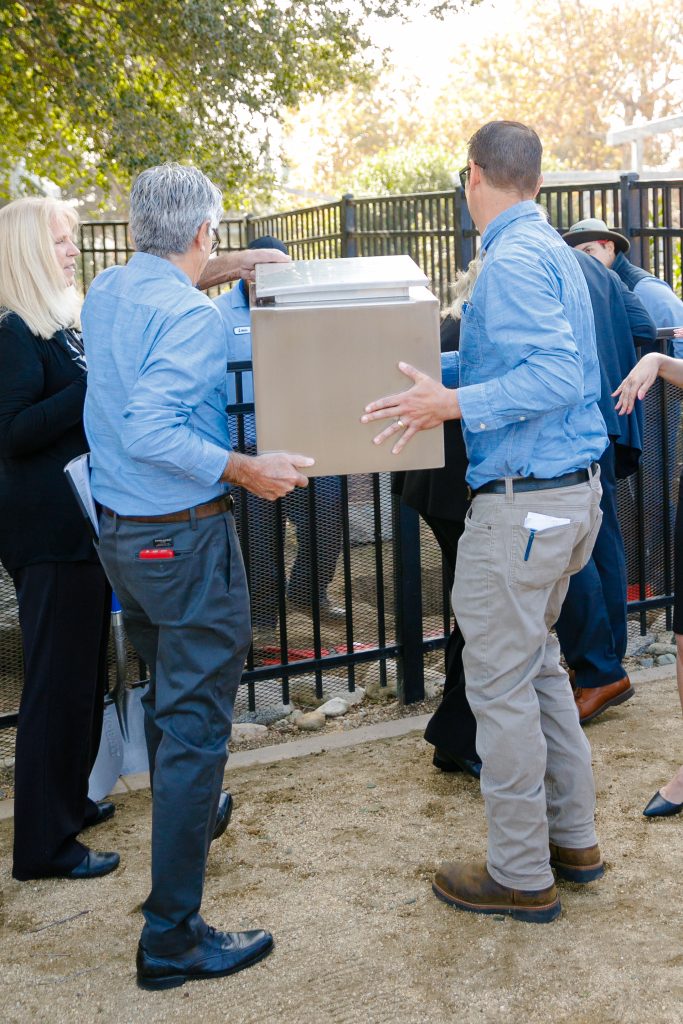 Two men carrying time capsule