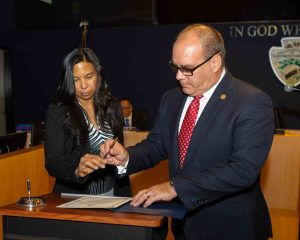 Rossana Hagman handing Supervisor Hagman a pen to sign his oath of office certificate.