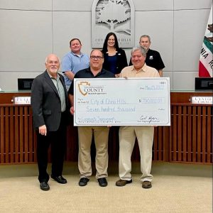 Supervisor Hagman presenting a large check in the amount of $700,000 to the Chino Hills City Council.