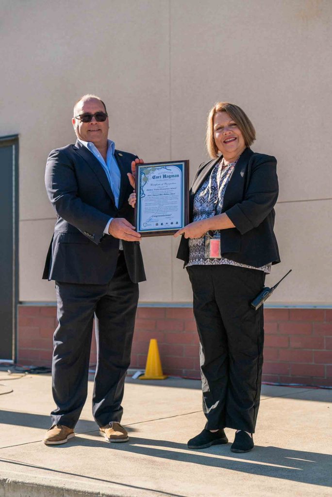 Supervisor Hagman presents Hidden Trails Elementary's Principal with a certificate celebrating their Blue Ribbon award.