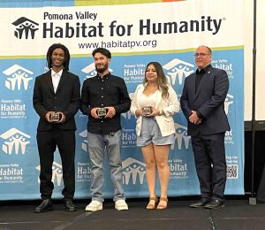 Supervisor Hagman standing on stage with recipients of a Habitat for Humanity award.