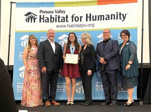 Supervisor on stage with City of Chino, Mayor Eunice Ulloa and the Habitat for Humanity award recipient.