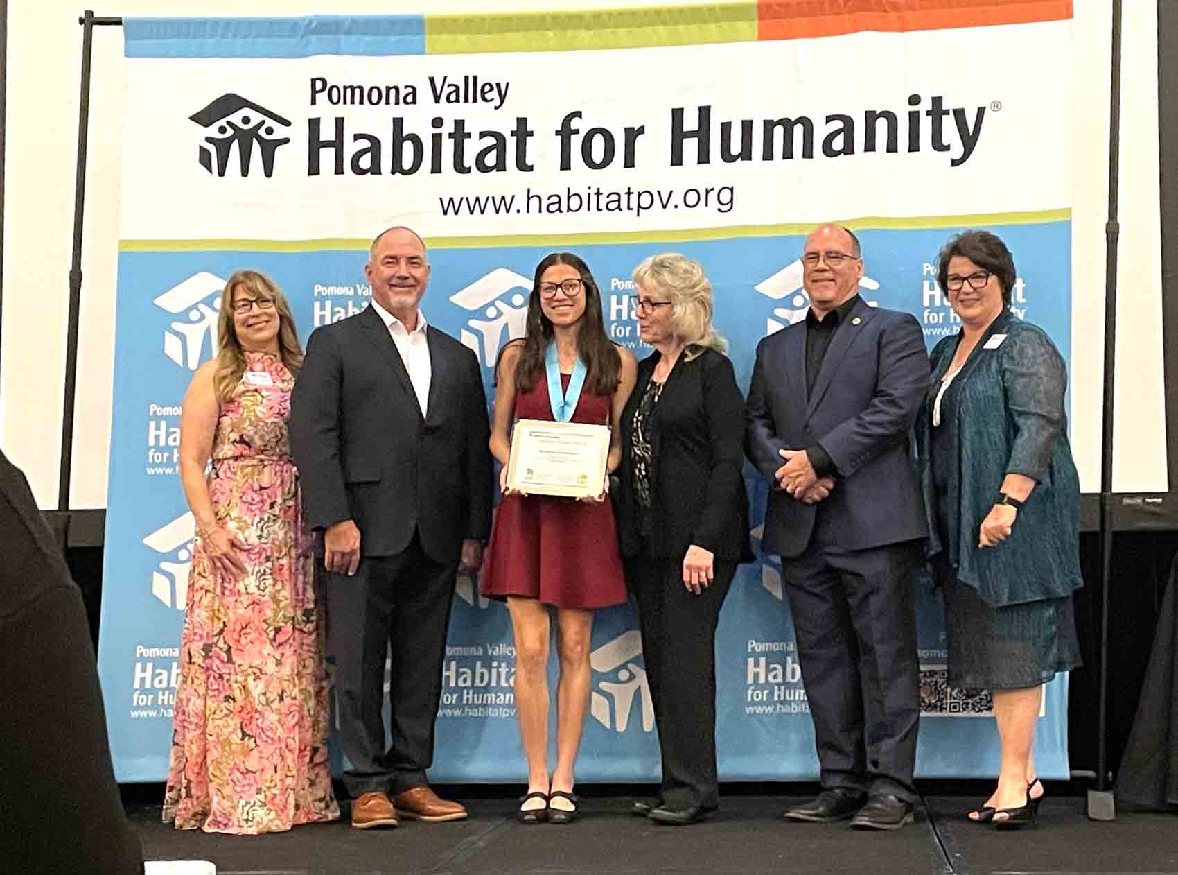 Supervisor on stage with City of Chino, Mayor Eunice Ulloa and the Habitat for Humanity award recipient.