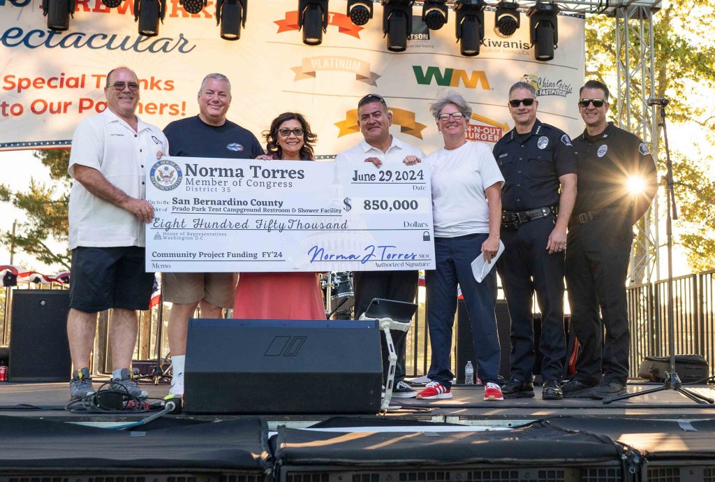 Supervisor Curt Hagman, Chino Councilmember Chris Burton, Congresswoman Norma Torres, Chino Councilmember Marc Lucio, Chino Councilmember Karen Comstock, Chino Police Chief Kevin Mensen and Chino Police Officer accepting the Community Project Funding Check for Prado Park renovations.