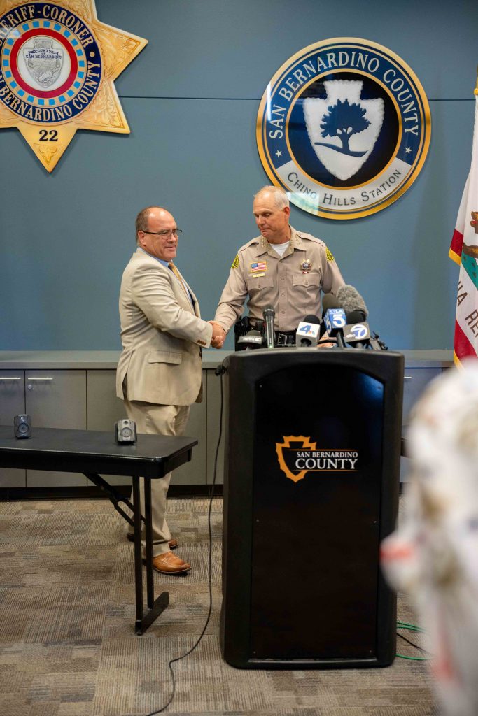 Sheriff Shannon Dicus shaking hands with Supervisor Curt Hagman while welcoming the Supervisor to the podium at the Body Worn Cameras Press Conference.