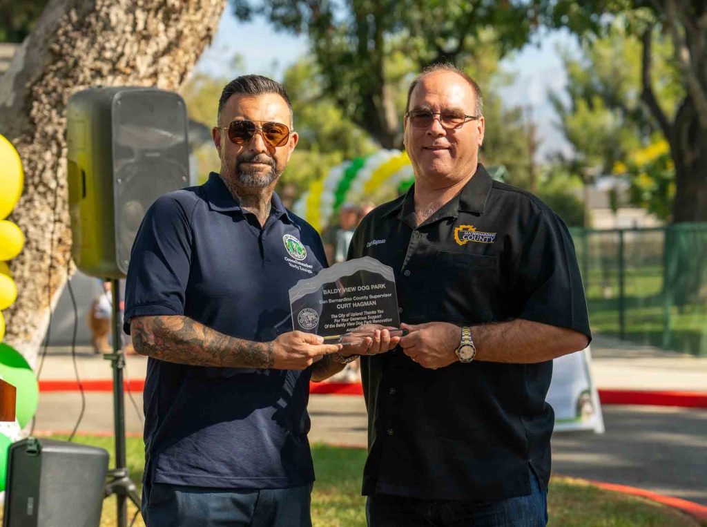 Supervisor Curt Hagman accepting an award from Upland City Councilmember Rudy Zuniga for his generous support of the Baldy View Dog Park Renovation Project.