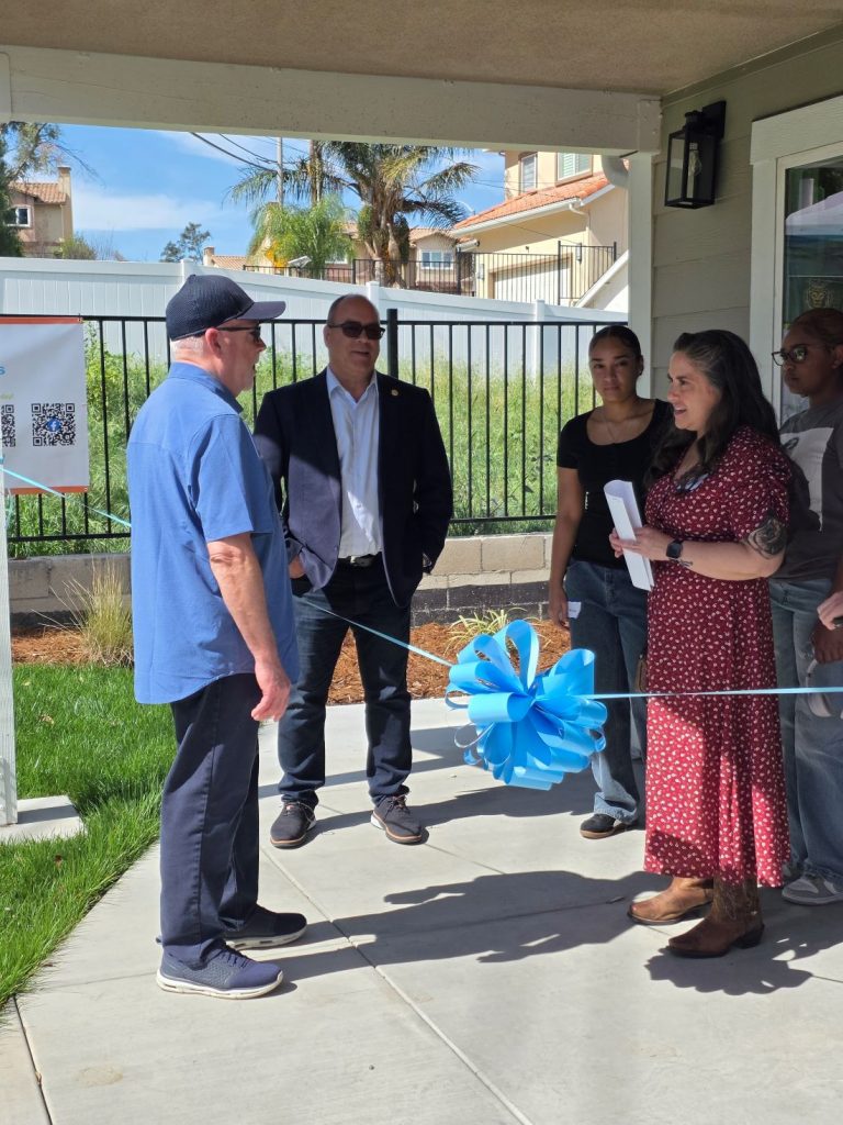 Supervisor Curt Hagman speaks with a family during Habitat for Humanity home dedication.