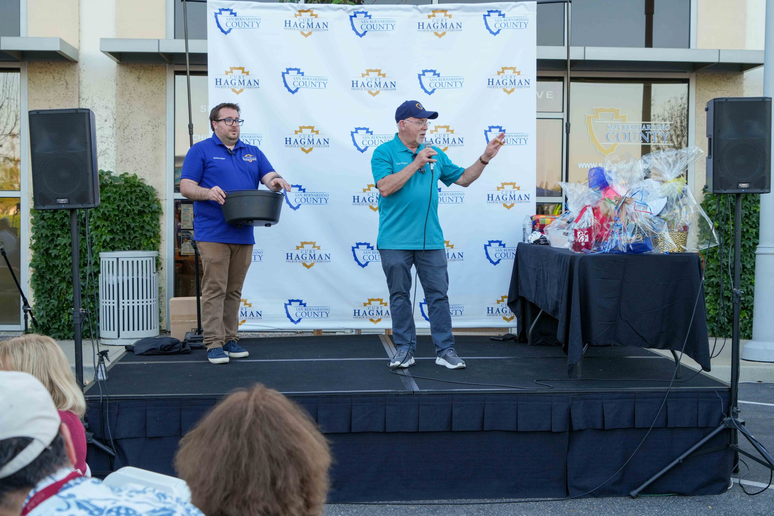 Two men lead an opportunity drawing on stage at the Summer Open House hosted by Supervisor Curt Hagman.