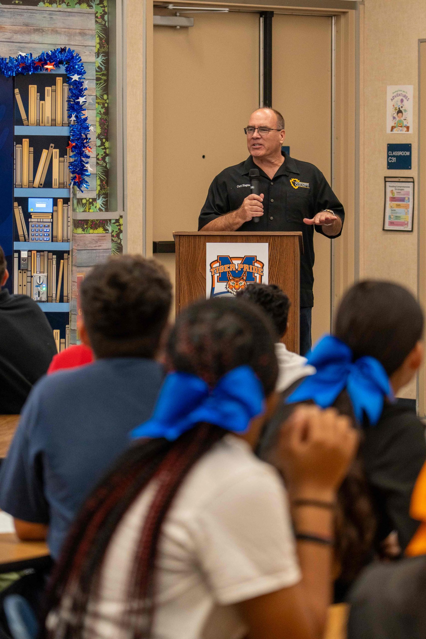 Supervisor Curt Hagman addresses students from the podium during the school book vending event.