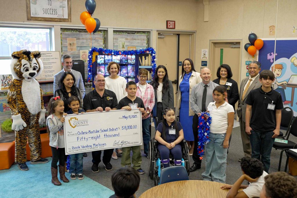 Supervisor Curt Hagman presents a $58,000 check to OMSD, accompanied by students, staff, and community partners.