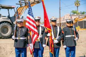 U.S. Marine Corps color guard presents flags at veterans housing groundbreaking ceremony.