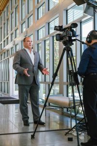 Supervisor Curt Hagman speaks on camera during an indoor interview at the 2022 West End Job Fair.