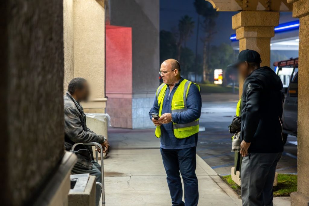 Supervisor Curt Hagman wearing a safety vest speaks with an unhoused resident outdoors during the 2026 Point-In-Time Count.