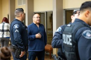 Supervisor Curt Hagman speaks with Ontario Police Officers inside a community center.
