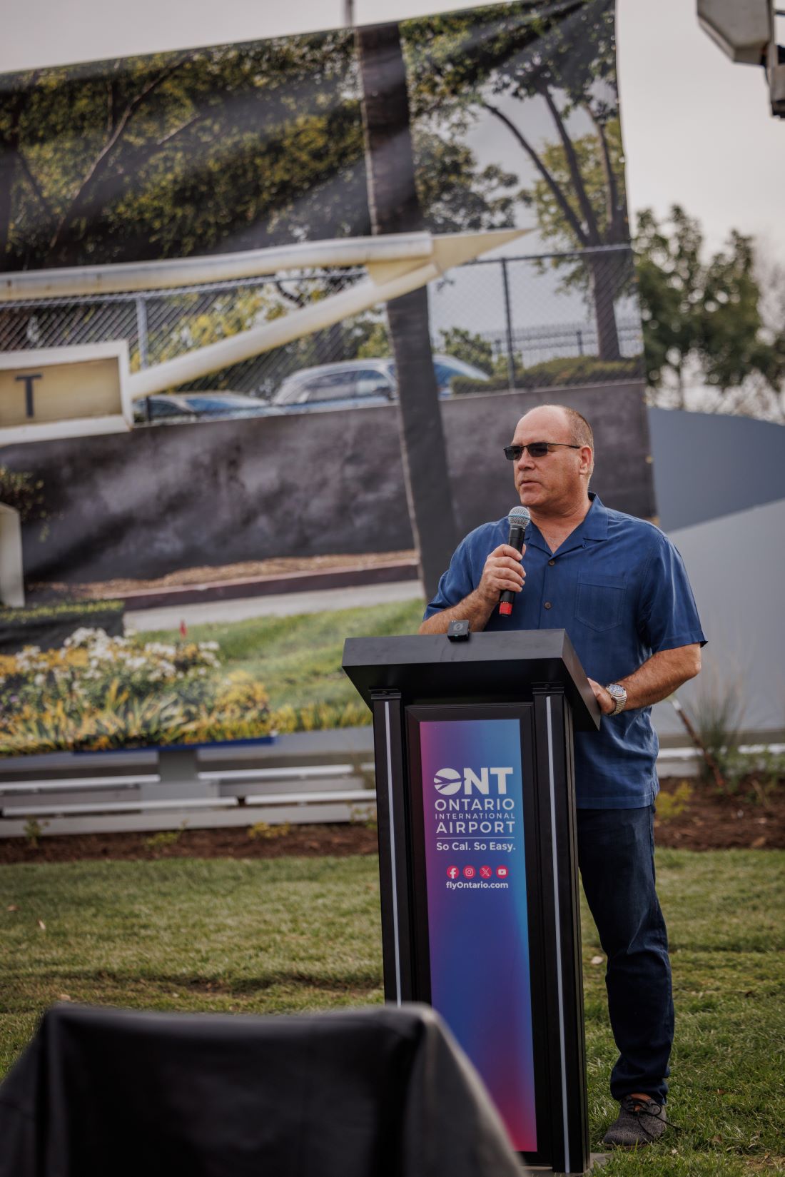 Supervisor Curt Hagman speaks at a podium during the Ontario International new monument unveiling event.