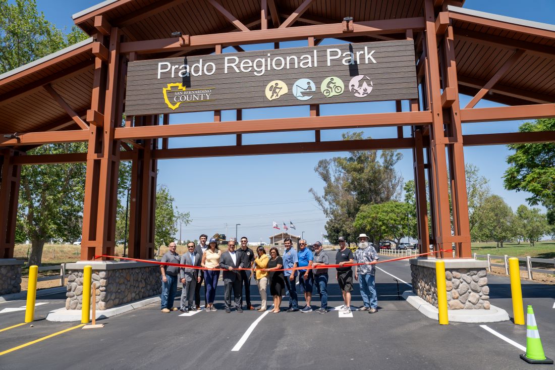 Officials and community leaders hold a ribbon during the grand opening of the new Prado Regional Park entrance gatehouse.