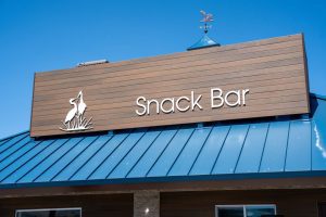 Close-up of the new Snack Bar sign on a building at Prado Regional Park.