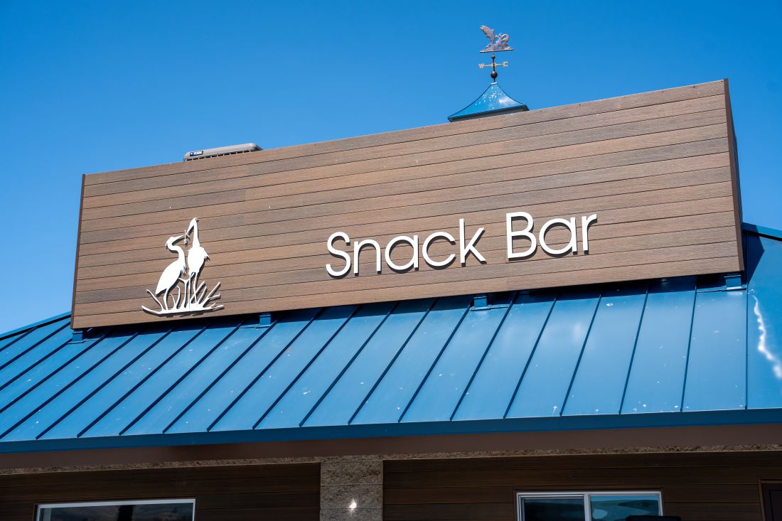 Close-up of the new Snack Bar sign on a building at Prado Regional Park.