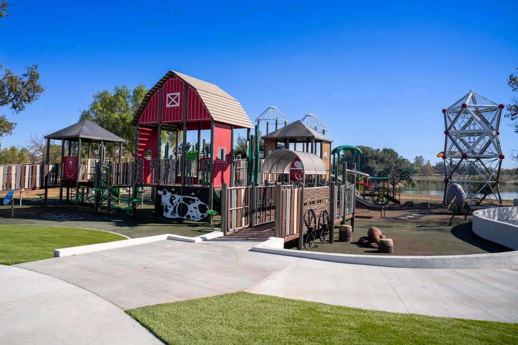 Photo of a playground. The playground takes on the look of barns and farm equipment.